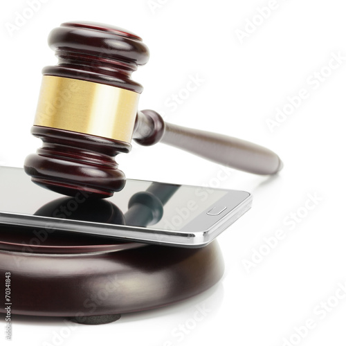 Smartphone between judge gavel and soundboard - 1 to 1 ratio photo