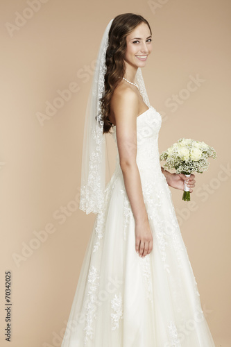Elegant young bride in wedding dress, studio shot.
