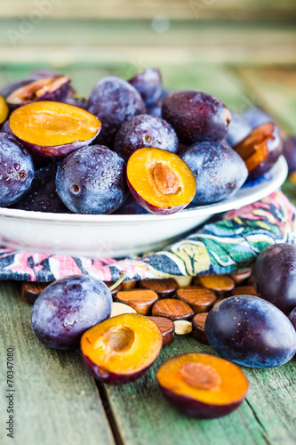 raw blue plums on a round plate,vegan