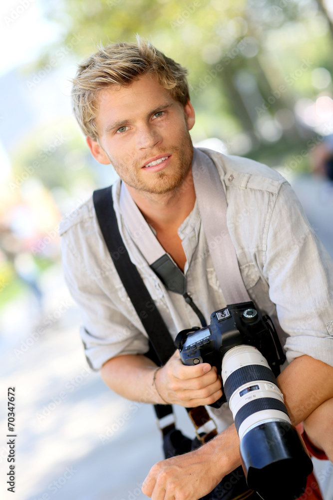 Portrait of handsome photographer holding camera Portrait of handsome photographer holding camera