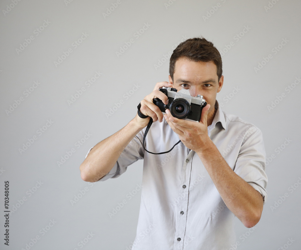 Fototapeta premium Photographer on grey background with vintage camera