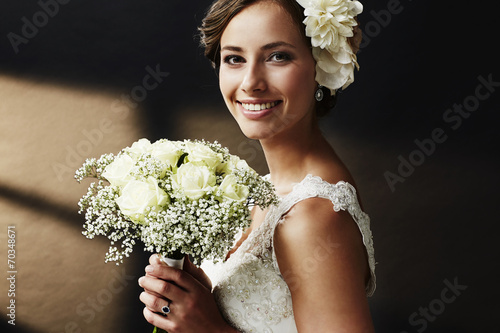 Obraz na plátně Stunning young bride holding bouquet, portrait.