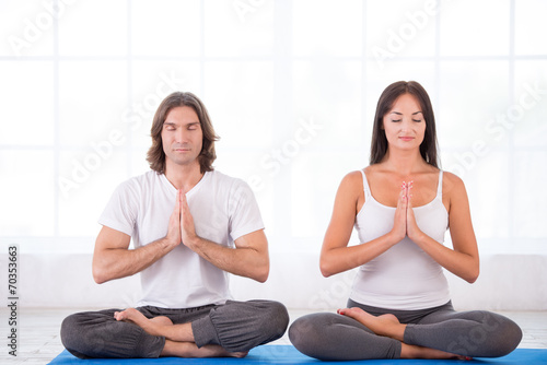 Young couple in lotus pose