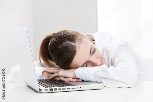 Young businessman sleeping on his laptop
