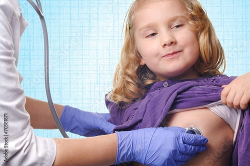 Photography Doctor examining child on blue background.