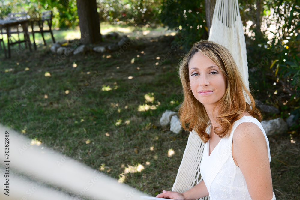 Naklejka premium cheerful young woman relaxing in a hammock summer