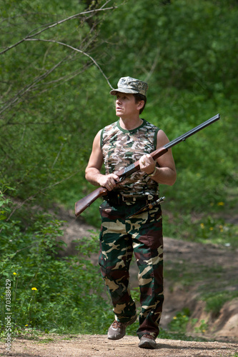 Hunter walking with rifle