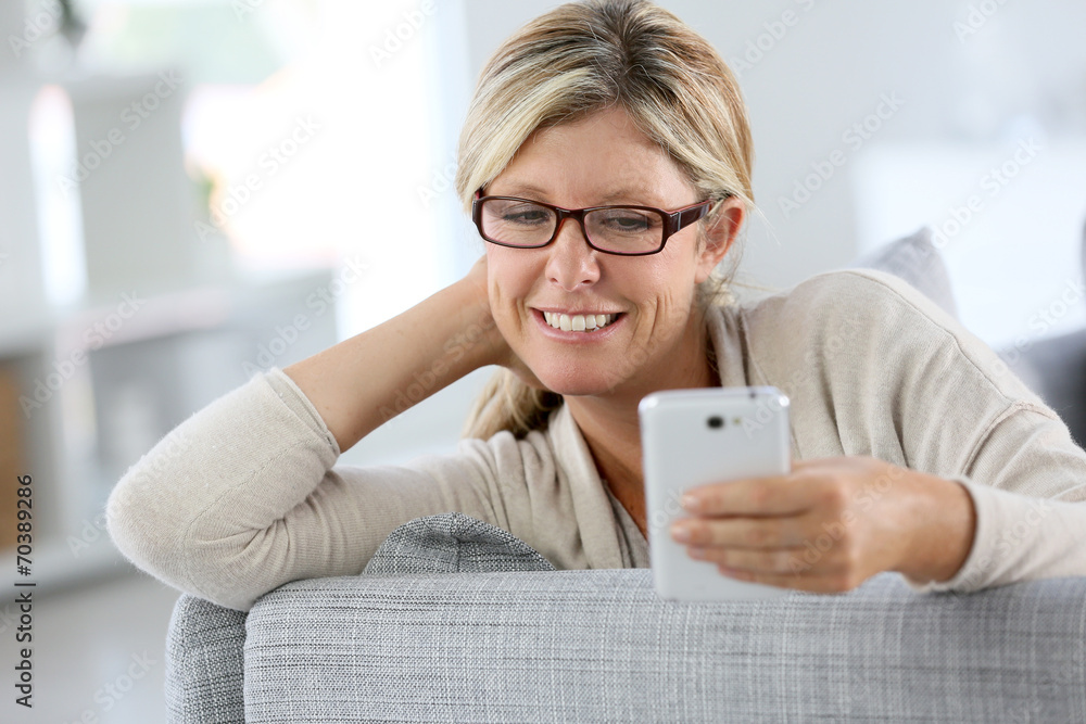 Cheerful woman reading text message on phone Cheerful woman reading text message on phone