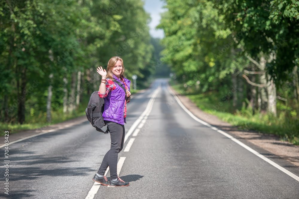 Beautiful girl with backpack walking on the road Beautiful girl with backpack walking on the road