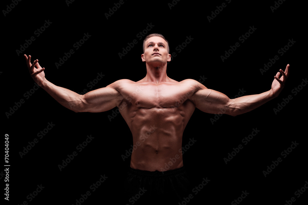 Muscular man gesturing with hands and looking up