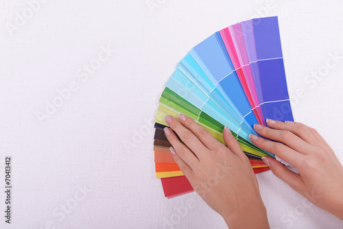 Woman choosing color for wall from swatches in room © Africa Studio