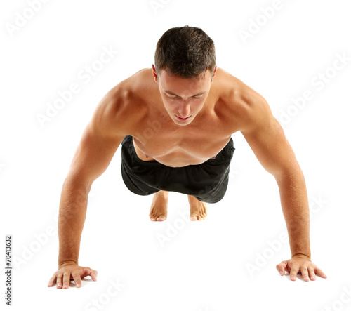 Handsome young muscular sportsman execute exercise isolated