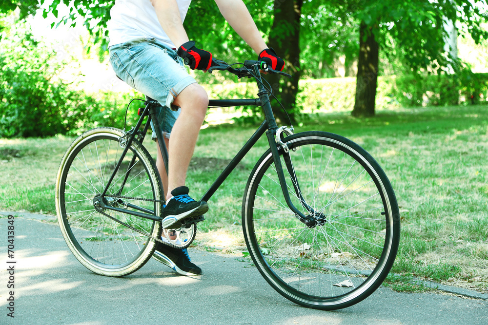 Fototapeta premium Man biking fast in city park. View from bikers eyes