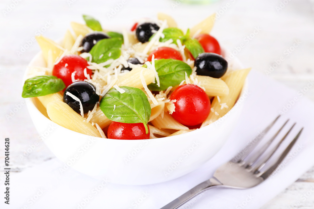 Pasta with tomatoes, olives and basil leaves in bowl Pasta with tomatoes, olives and basil leaves in bowl