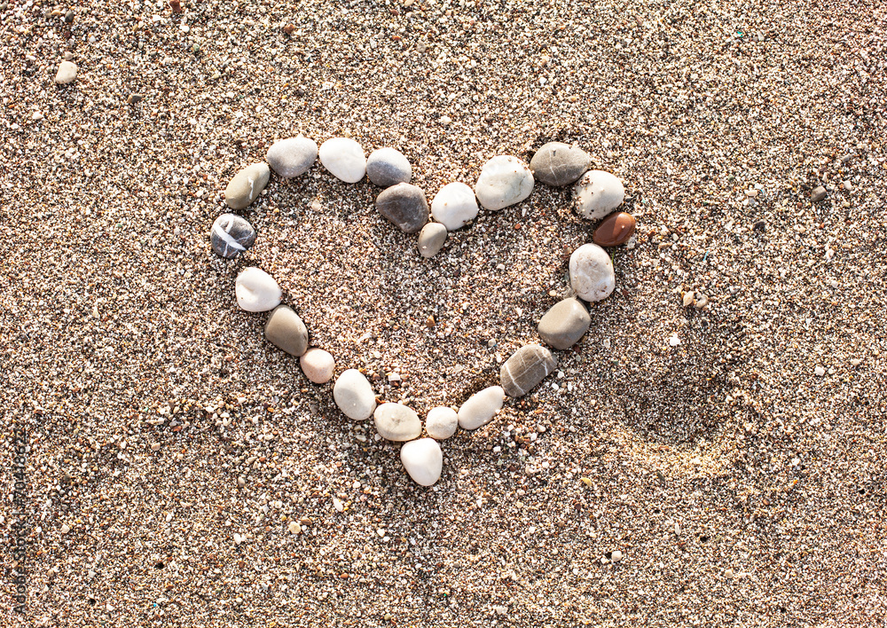 Heart of marine shingles on the sand. - obrazy, fototapety, plakaty 