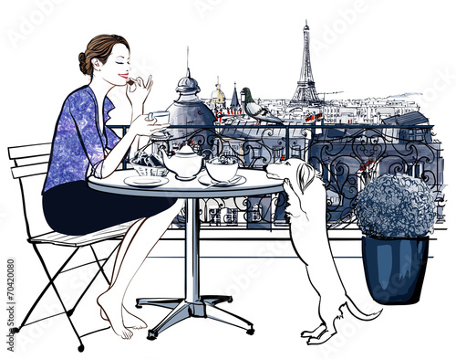 Woman having breakfast on a balcony in Paris