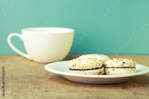 macaroons on a wooden table with cup of coffee retro blue background