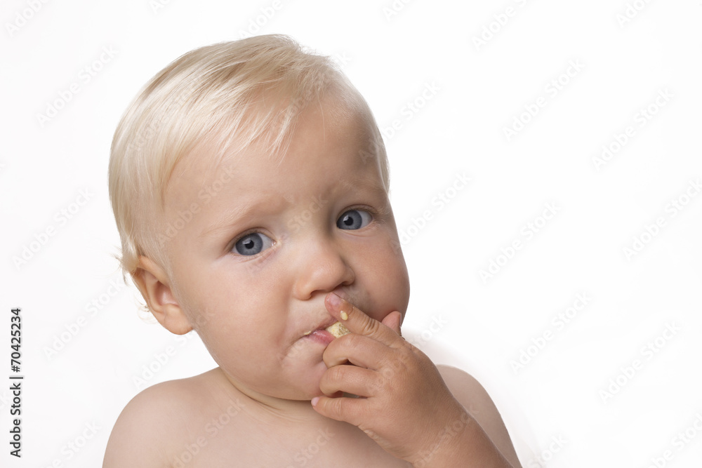 One year old boy eating himself corn snack One year old boy eating himself corn snack