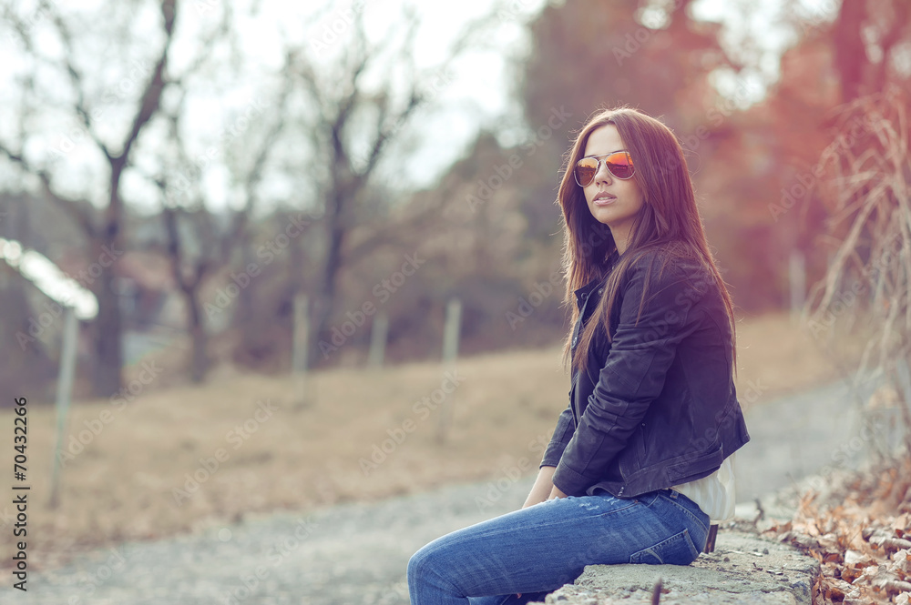 Young sexy brunette woman in jeans, jacket and sunglasses posing Young sexy brunette woman in jeans, jacket and sunglasses posing