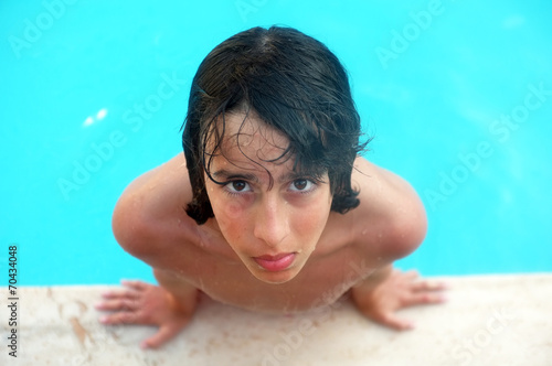 Young teenage boy looks up in swimming pool