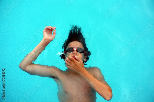 Young teenage boy laying on water