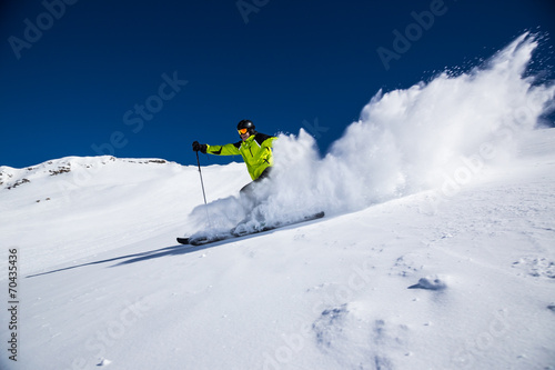 Alpine skier on piste, skiing downhill #70435436