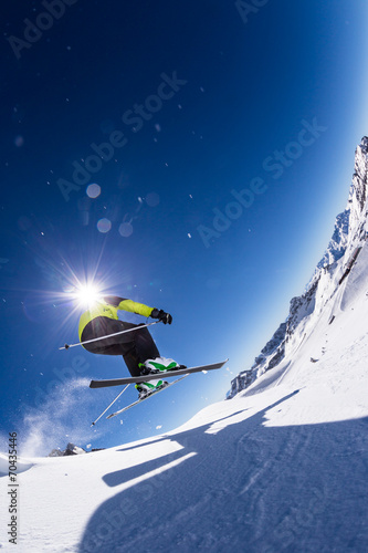 Alpine skier on piste, skiing downhill