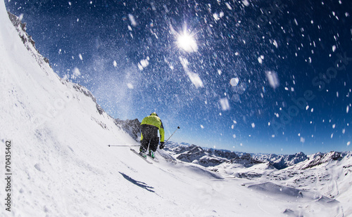 Alpine skier on piste, skiing downhill