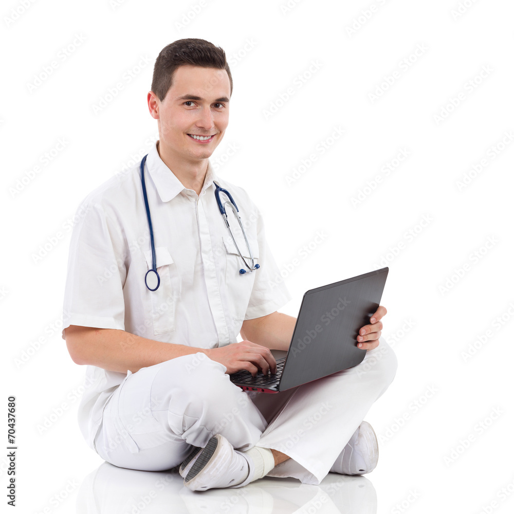 Smiling male medicine student with a laptop Smiling male medicine student with a laptop