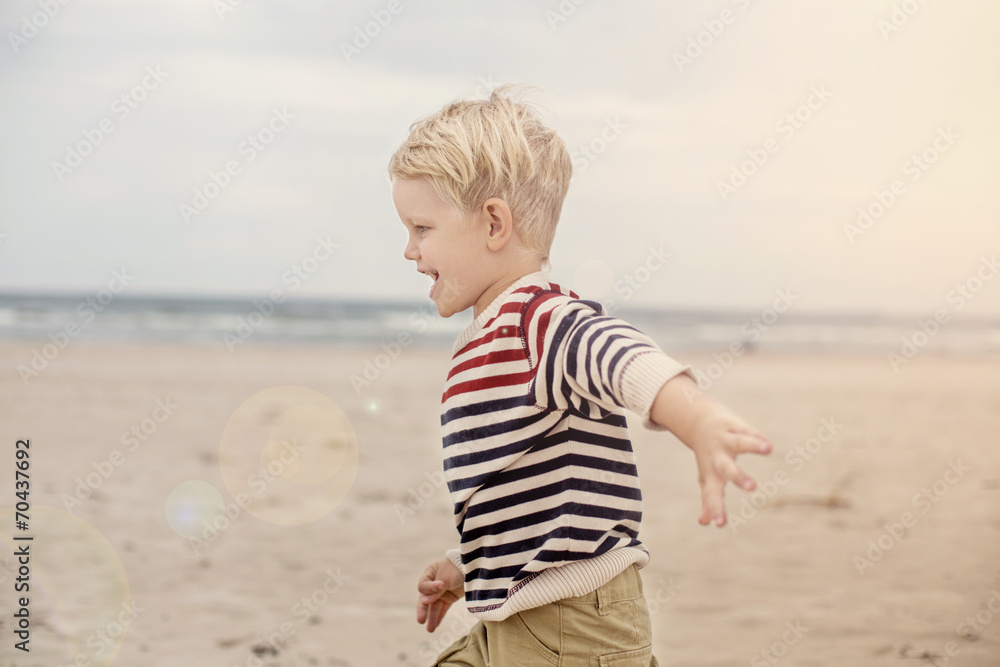 happy kid running on the sea beach. Oudoor portrait