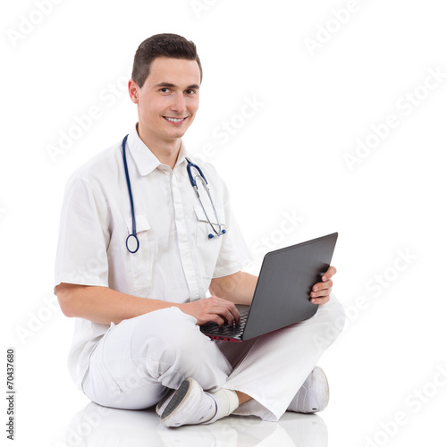 Smiling male medicine student with a laptop