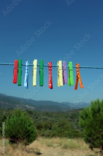 Multicolored clothespin hanged on a blue cord