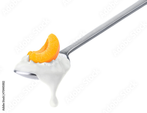 Isolated yogurt. Spoon of peach or apricot yogurt isolated on white, with clipping path