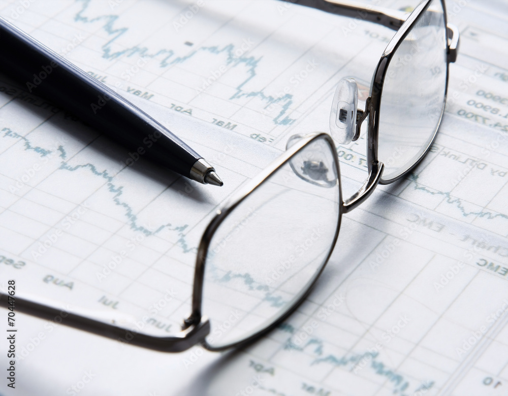 Eyeglasses lying down on a business document Eyeglasses lying down on a business document