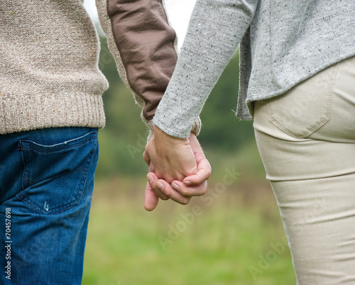 Male and female holding hands outdoors