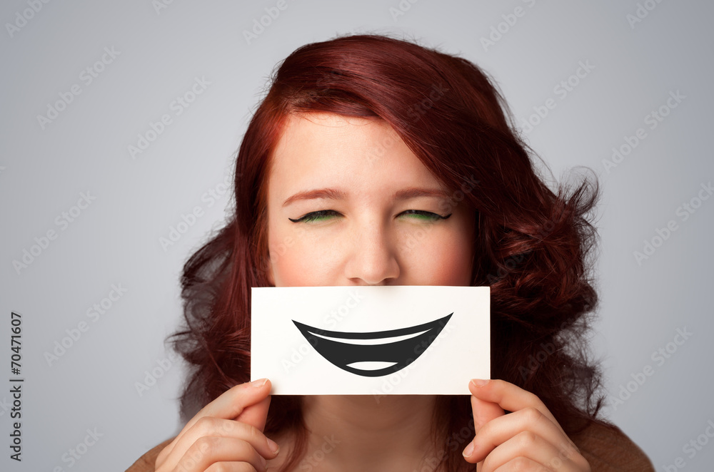 Happy pretty woman holding card with funny smiley Happy pretty woman holding card with funny smiley