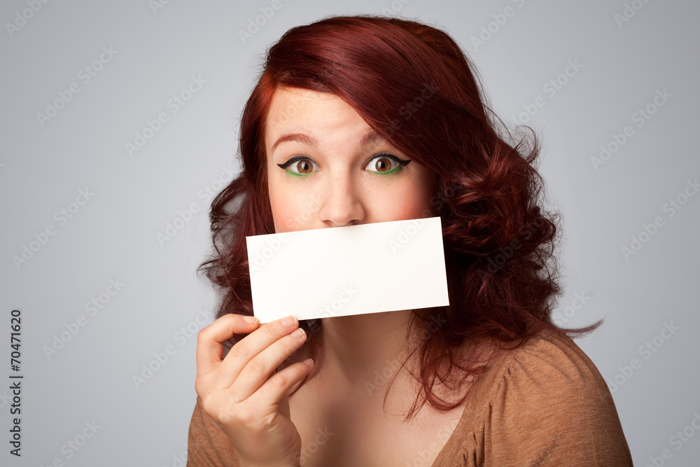 Cute girl holding white card at front of her lips with copy spac Cute girl holding white card at front of her lips with copy spac