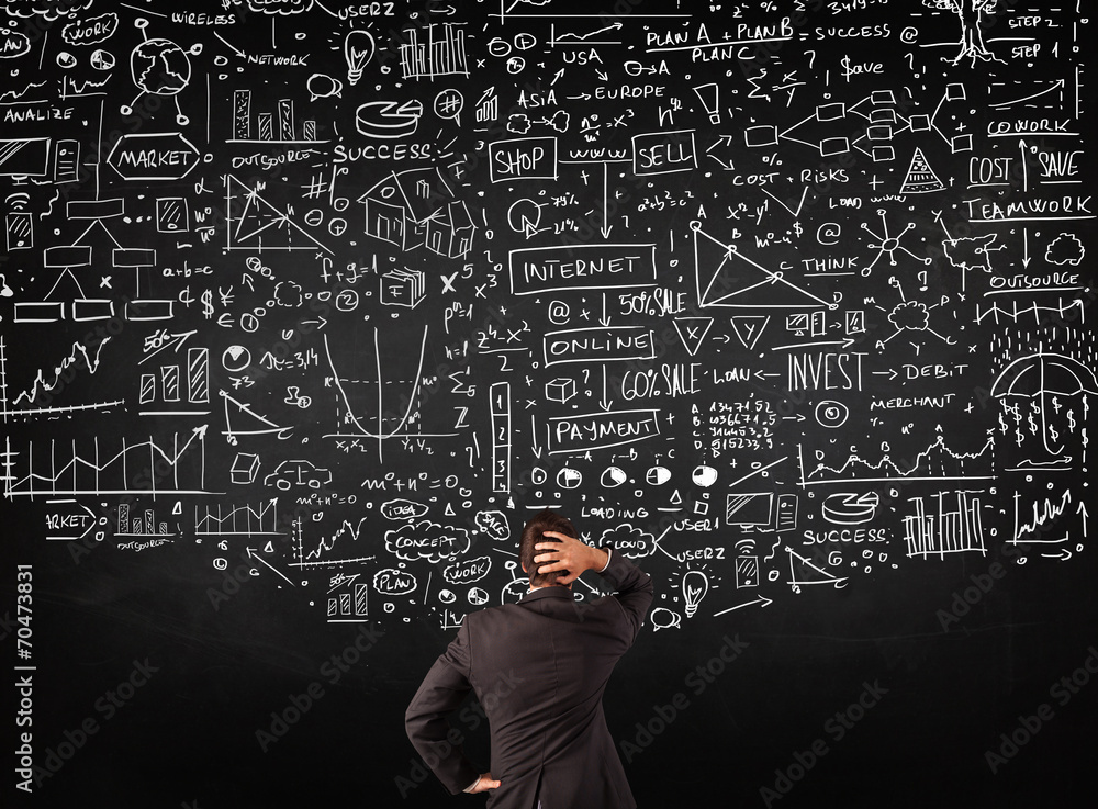 Businessman standing in front of drawn charts on a blackboard Businessman standing in front of drawn charts on a blackboard