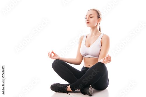 Young woman sitting in lotus position isolated