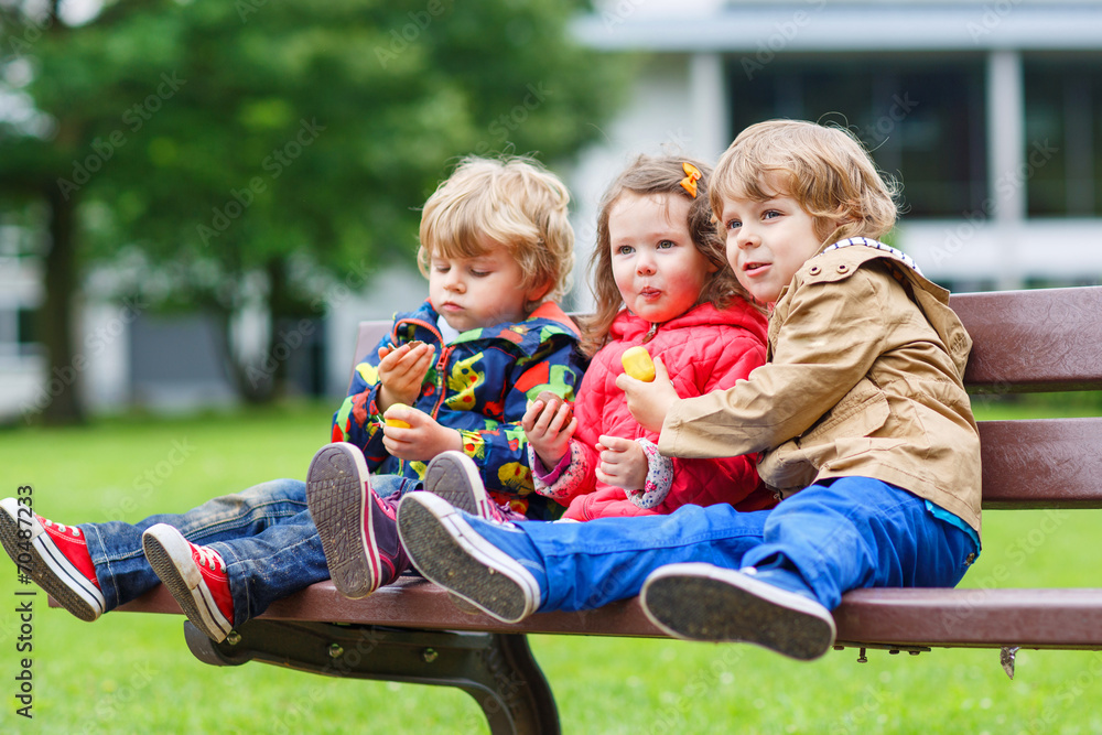 Fototapeta premium Three children: two little brothers and one sister hugging