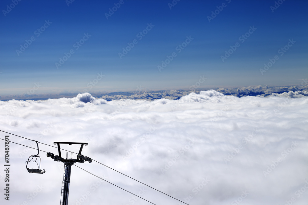 Mountains under clouds and chair-lift