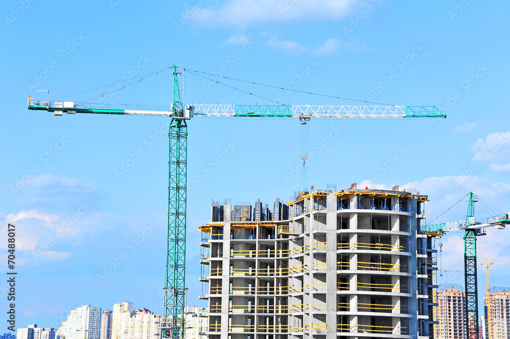 Crane and building construction site against blue sky