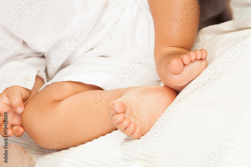 Piedi di un neonato che dorme su un lenzuolo bianco