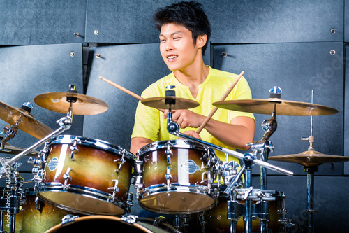 Photo Asian musician drummer in recording studio