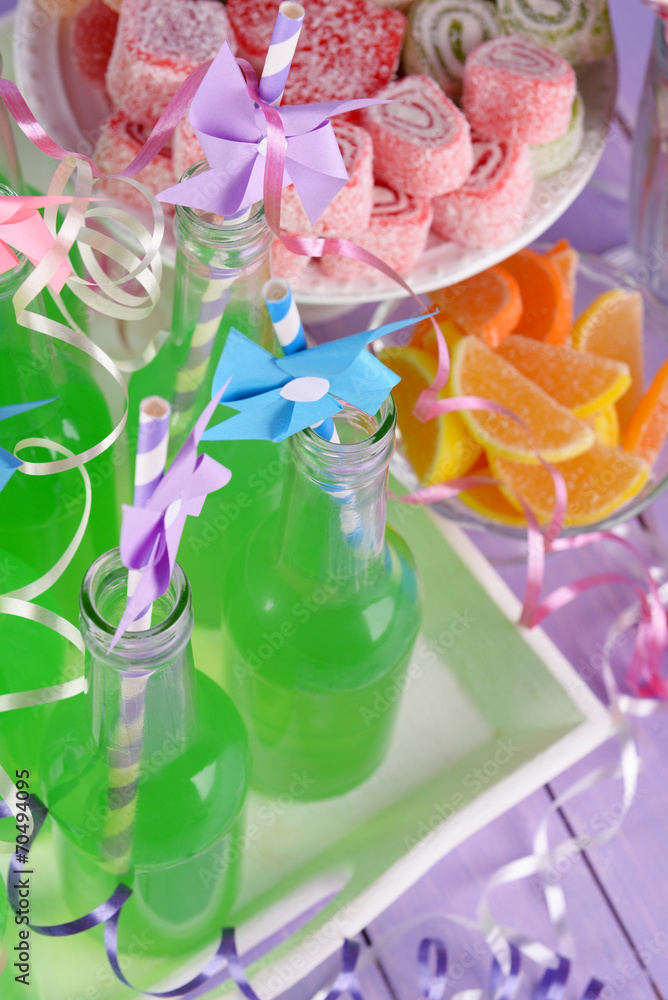 Bottles with drink and sweets on wooden background Bottles with drink and sweets on wooden background