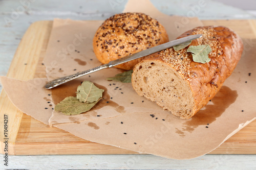Fresh baked bread, on cutting board, on wooden background