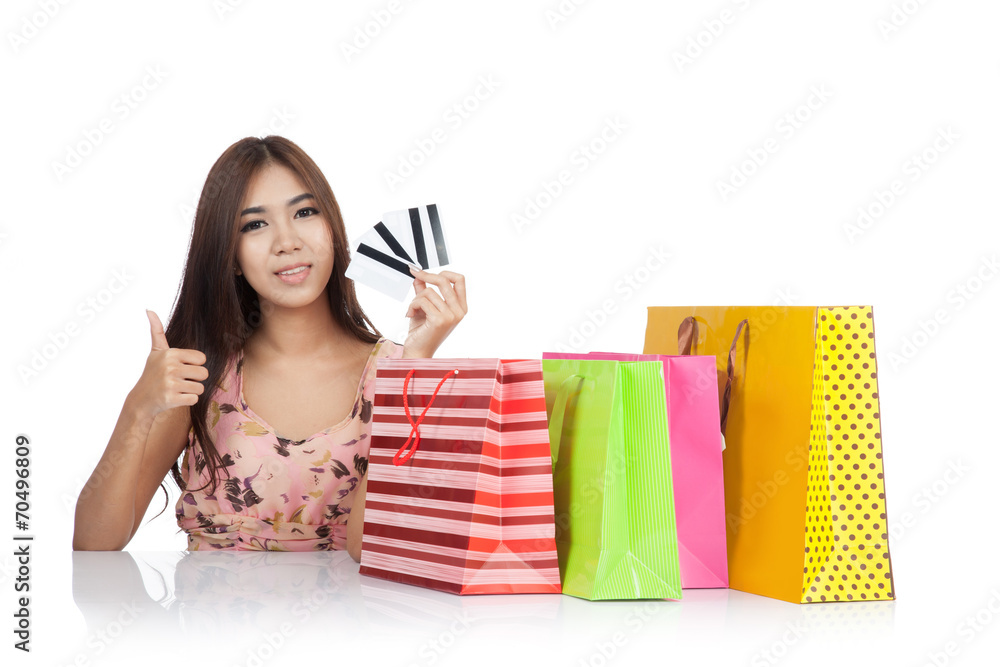 Happy Asian woman thumbs up with credit cards and shopping bags Happy Asian woman thumbs up with credit cards and shopping bags