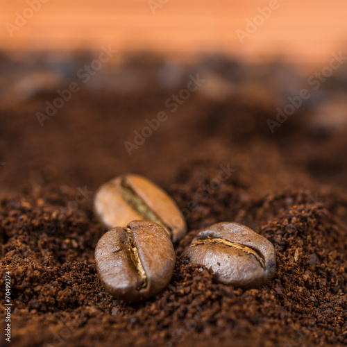 Close-up of coffee beans with roasted coffee heap.