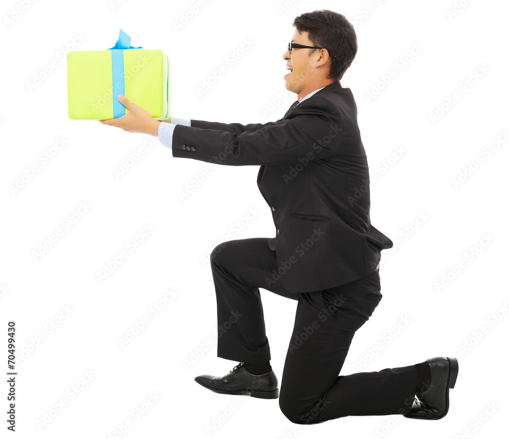 young Business man holding a gift box and kneel. young Business man holding a gift box and kneel.