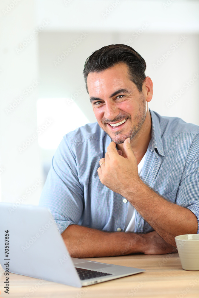 Mature man working at home with laptop Mature man working at home with laptop